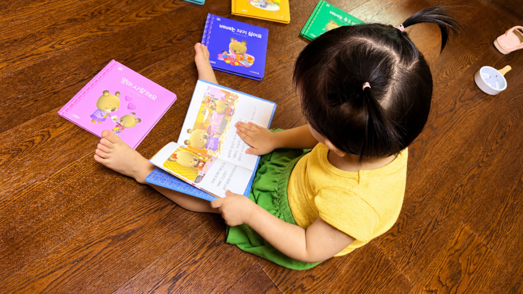 Toddler reading a Korean picture book at home