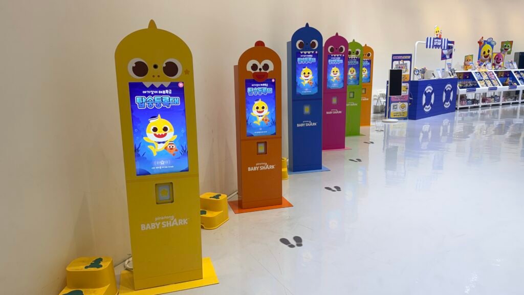 Child registering a Star Band at the Baby Shark exhibition kiosk