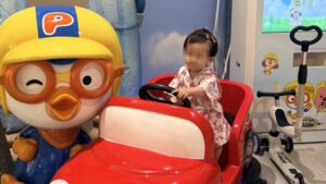 Toddler riding a toy car at Pororo Theme Park Dasan
