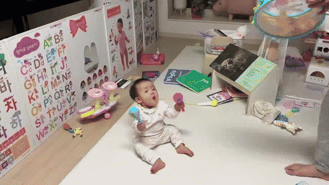 Toddler playing the drum from a Pinkfong Baby Shark instrument set