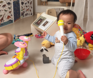 Toddler singing into the microphone of a Pororo drum toy