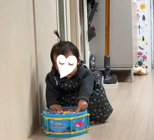 Toddler playing with a Pinkfong Baby Shark musical instrument set
